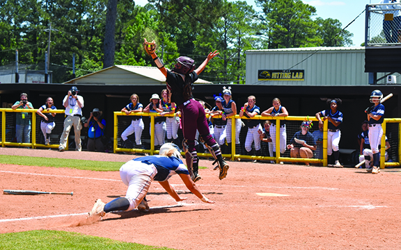 Catcher Emma Rush jumps for the high ball at home plate.