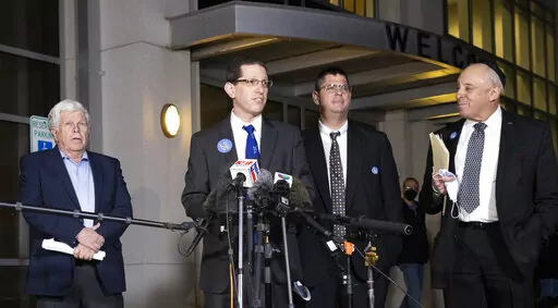 Charlie Cytron-Walker, rabbi of Congregation Beth Israel, center, makes a statement to the media after a service at White's Chapel United Methodist Church in Southlake, Texas, Monday, Jan. 17, 2022. The church held a healing service for congregants and members of the community after Saturday's standoff at the synagogue. (Rebecca Slezak/The Dallas Morning News via AP)
