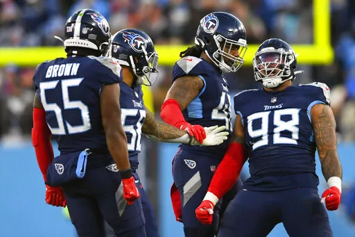Tennessee Titans defensive end Jeffery Simmons (98) celebrates his sack of Cincinnati Bengals quarterback Joe Burrow during the first half of an NFL divisional round playoff football game Jan. 22, 2022, in Nashville, Tenn. Simmons not only reported for Tennessee training camp on time, the Pro Bowl defensive tackle has refused to talk about his contract and made clear he is focused only on working to improve going into his fourth season. (AP Photo/John Amis, File)