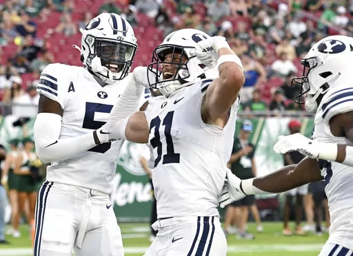 BYU linebacker Max Tooley (31) celebrates after returning an interception for a touchdown during the first half of an NCAA football game against South Florida Saturday, Sept. 3, 2022, in Tampa, Fla. (AP Photo/Jason Behnken)