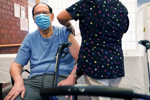 FILE - Marvin Marcus, 79, a resident at the Hebrew Home at Riverdale, receives a COVID-19 booster shot in New York, Sept. 27, 2021.  Federal health officials call on nursing homes to redouble efforts to administer COVID-19 booster shots to residents and staff amid sharply rising cases among staff and lagging rates of booster vaccination.  (AP Photo/Seth Wenig, File)