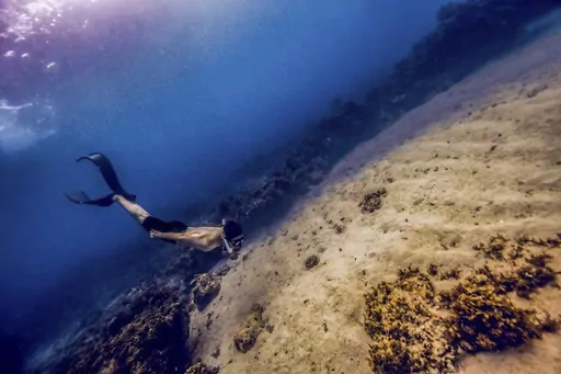 Chinese Wanxiong Huang, a free diving instructor, practices his skills in the sea around Bohol Island in the Philippines, April 16, 2023. A growing number of young Chinese are moving overseas, frequently to Southeast Asia, to escape their homeland's ultra-competitive work culture, limited opportunities and family pressures. There is no exact data on the number of the moves, the popular Chinese social media platform Xiaohongshu, hundreds of people have discussed relocating to Thailand. (AP Photo/