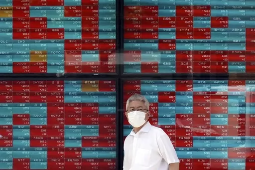 A person stands in front of an electronic stock board showing Japan's Nikkei 225 index at a securities firm in Tokyo, on Sept. 11, 2023. Asian shares were mostly higher in thin trading Monday, Oct. 2, 2023 with many markets closed for holidays. (AP Photo/Eugene Hoshiko, File)