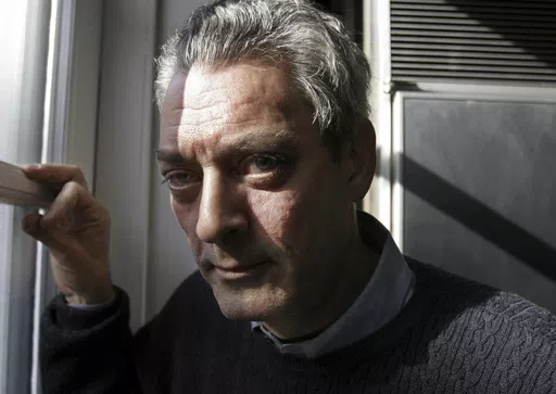 Writer Paul Auster poses at his home in the Brooklyn borough of New York, Jan. 19, 2006. Paul Auster, a prolific, prize-winning man of letters and filmmaker known for such inventive narratives and meta-narratives as “The New York Trilogy” and “4 3 2 1,” has died at age 77. (AP Photo/Bebeto Matthews, File)