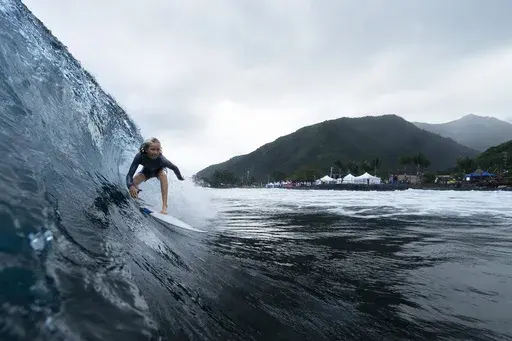 Kelia Gallina, 11, surfs her home shore break during a break in the 2024 Summer Olympics surfing competition, Wednesday, July 31, 2024, in Teahupo'o, Tahiti. While Teahupo'o has been a coveted destination for surfers from around the world for decades, it's only in more recent years that local surf culture and talent has begun to develop across Tahiti. (AP Photo/Gregory Bull)