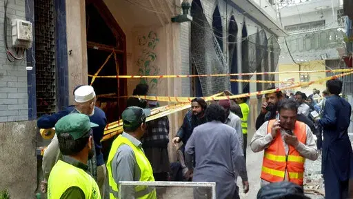Rescue workers and volunteers gather at the site of bomb explosion in Peshawar, Pakistan, Friday, March 4, 2022. A powerful bomb exploded inside a Shiite Muslim mosque in Pakistan's northwestern city of Peshawar on Friday, killing more than 30 worshippers and wounding dozens more, many of them critically, police said. (AP Photo/Muhammad Sajjad)