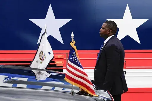 A U.S. Secret Service agent stands watch outside a campaign bus for Democratic presidential nominee Vice President Kamala Harris and her running mate Minnesota Gov. Tim Walz, Aug. 18, 2024, in Rochester, Pa. (AP Photo/Julia Nikhinson, File)