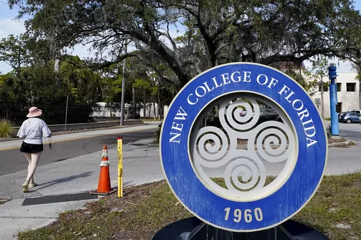 A student makes her way past the sign at New College of Florida, Jan. 20, 2023, in Sarasota, Fla. The New College of Florida trustees dominated by conservatives appointed by Gov. Ron DeSantis chose a new mascot on Thursday, June 1, 2023, for the Sarasota school: The Mighty Banyans. The tree mascot will replace one that has been in use since 1997, which is the mathematical formulation of the Null Set. (AP Photo/Chris O'Meara, File)