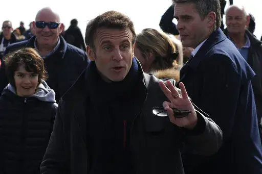 French President and centrist presidential candidate for reelection Emmanuel Macron gestures as he strolls after voting for the first round of the presidential election, Sunday, April 10, 2022 in Le Touquet, northern France. Polls opened across France for the first round of the country's presidential election, where up to 48 million eligible voters will be choosing between 12 candidates. President Emmanuel Macron is seeking a second five-year term, with a strong challenge from the far right. (AP