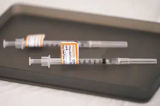 Prepared Pfizer COVID-19 vaccine syringes for children ages 5 to 11 and adults are displayed on a table at Northwest Community Church in Chicago, Dec. 11, 2021. The Biden administration said Thursday, June 2, 2022, that children under 5 may be able to get their first COVID-19 vaccination doses as soon as June 21, if federal regulators authorize shots for the age group, as expected. (AP Photo/Nam Y. Huh, File)