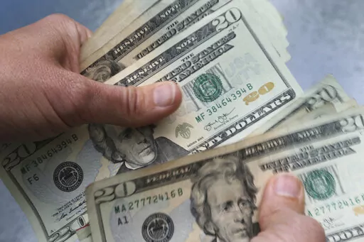 In this June 15, 2018 file photo, twenty dollar bills are counted in North Andover, Mass. Most people have an inner critic that sometimes judges their actions and behaviors, including those related to money. That voice may label them as overspenders, for example, or insist they’ll never understand investing. Claims like those can be self-fulfilling. Why reel in spending or learn about investing if you’ve already determined you can’t do so?   (AP Photo/Elise Amendola, File)