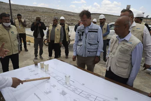 U.N. Deputy Regional Humanitarian Coordinator for the Syria Crisis David Carden, center, inspects a wastewater treatment project in the village of Bhora, in Idlib province, Syria, Tuesday, May 14, 2024. Syria's devastating civil war, now in its 14th year, remains largely frozen and so are efforts to find a viable political solution to end it, while millions of Syrians have been pulled into poverty, and struggle with accessing food and health care as the economy deteriorates across the country's 