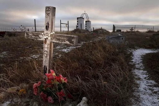 This Feb. 7, 2012 photo shows a cross on a grave at the Wounded Knee National Historic landmark in South Dakota. Two American Indian tribes in South Dakota have agreed to purchase 40 acres of land near the Wounded Knee National Historic Landmark on the Pine Ridge Indian Reservation. (Rapid City Journal via AP)