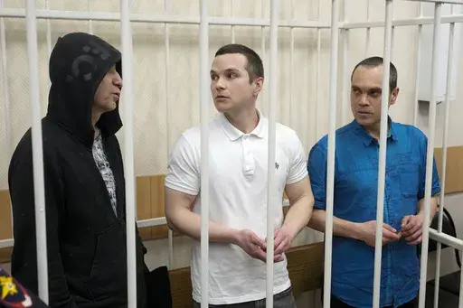 Lawyers Igor Sergunin, from left, Alexei Liptser and Vadim Kobzev, all who once represented late opposition leader Alexei Navalny, stand in a courtroom in Petushki, Vladimir region, about 120 kilometers (75 miles) east of Moscow, Russia, Friday, Jan. 17, 2025. (AP Photo/Pavel Bednyakov)