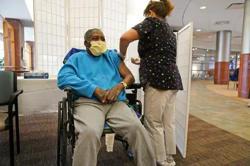 Edward Williams, 62, a resident at the Hebrew Home at Riverdale, receives a COVID-19 booster shot in New York Sept. 27, 2021. Medicare says it's shining a light on key markers for nursing home quality. Starting Wednesday, the program is posting details on staff turnover and weekend nurse coverage on its “Care Compare” website, where families research individual facilities. (AP Photo/Seth Wenig, File)