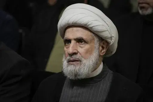 Hezbollah's deputy leader, Sheikh Naim Kassem, listens to a speech by then-leader Hassan Nasrallah on a screen in southern Beirut, Wednesday, June 19, 2024. (AP Photo/Bilal Hussein, File)