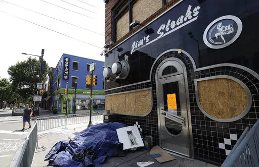 Jim's Steaks along 4th and South Streets is boarded up on Sunday, July 31, 2022, following a fire in Philadelphia. An electrical malfunction sparked a fast-moving fire that damaged one of Philadelphia’s best-known cheesesteak shops last week, authorities said. (Yong Kim/The Philadelphia Inquirer via AP)