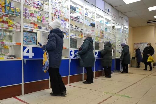 Customers stand at the windows buying medicines in a pharmacy in St. Petersburg, Russia, Friday, April 1, 2022. (AP Photo)