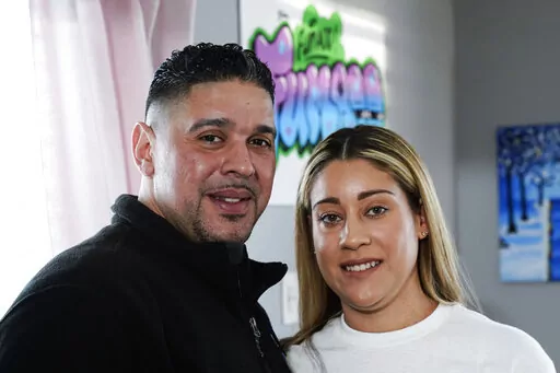 Eladio and Melissa Guzman pose for photographs, Monday, April 4, 2022, in Hicksville, N.Y. The couple, who endured the war on drugs, including jail time, are now eager to open a recreational marijuana dispensary in New York. (AP Photo/Frank Franklin II)