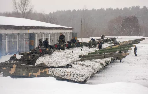 Ukrainian soldiers examine their tanks at a military unit close to Kharkiv, Ukraine, Monday, Jan. 31, 2022. Russia's foreign minister claims that NATO wants to pull Ukraine into the alliance, amid escalating tensions over NATO expansion and fears that Russia is preparing to invade Ukraine. (AP Photo/Andrew Marienko)