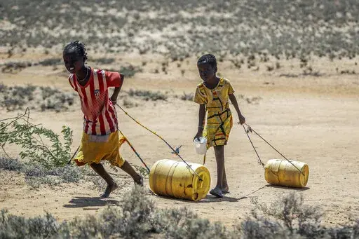 Young girls pull containers of water during a drought as they return to their huts from a well in the village of Lomoputh in northern Kenya on, May 12, 2022. Better climate-related research and early weather warning systems are needed as extreme weather — from cyclones to drought — continues to inflict the African continent, said the Sudanese billionaire and philanthropist Mo Ibrahim, who heads up his own foundation. (AP Photo/Brian Inganga, File)