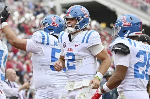 Mississippi quarterback Jaxson Dart (2) celebrates with teammates after throwing a touchdown pass to Jordan Watkins (11) against Arkansas during the second half of an NCAA college football game Saturday, Nov. 2, 2024, in Fayetteville, Ark. (AP Photo/Michael Woods)