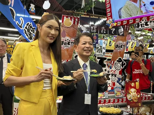 Japanese Agriculture Minister Ichiro Miyashita, right, and Malaysian celebrity Amber Chia attend an event at Japanese store, Don Don Donki in Kuala Lumpur Wednesday, Oct. 4, 2023 to promote the safety and deliciousness of Japanese scallops to shoppers. Japan hopes to resolve the issue of China's ban on its seafood within the scope of the World Trade Organization ambit and will hold food fairs overseas to bolster seafood exports amid safety concerns over the release of treated water from the Fuku