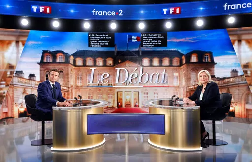 Centrist candidate and French President Emmanuel Macron, left, and far-right contender Marine Le Pen pose before a televised debate in La Plaine-Saint-Denis, outside Paris, Wednesday, April 20, 2022. In the climax of France's presidential campaign, centrist President Emmanuel Macron and far-right contender Marine Le Pen meet Wednesday evening in a one-on-one television debate that could prove decisive before Sunday's runoff vote. (Ludovic Marin, Pool via AP)