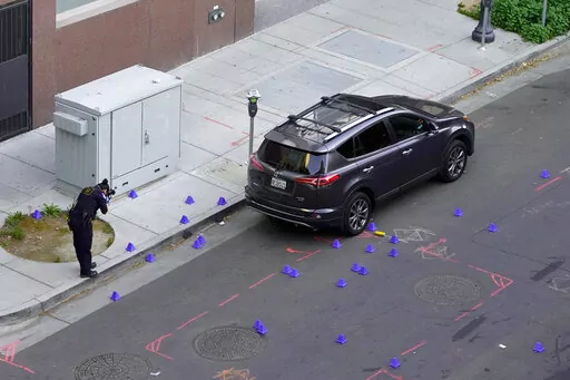 A crime scene investigator photograph evidence markers at the scene of a mass shooting In Sacramento, Calif. April 3, 2022. (AP Photo/Rich Pedroncelli)