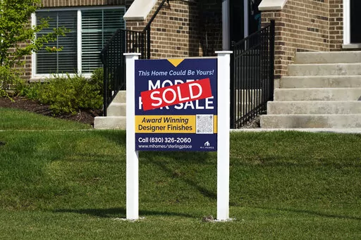 An advertising sign for building land stands in front of a new home construction site in Northbrook, Ill., Wednesday, Sept. 21, 2022. From rising home prices to soaring interest rates, it’s a daunting time to be a home buyer. To achieve homeownership, some single buyers are trying a different approach: co-buying with friends or family members. But co-buying isn’t a short-term hack – it’s a lifestyle shift. Before you team up, experts recommend having vulnerable conversations about your f