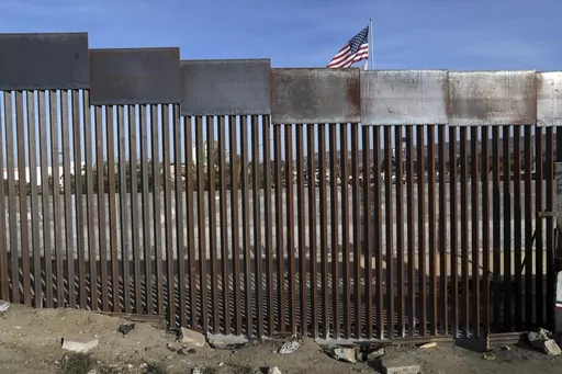 A United States flag flies behind the border fence that divides Mexico and the U.S., in Tijuana, Mexico, Nov. 21, 2018. Nearly a thousand migrants that recently crossed from Guatemala into Mexico formed a group Saturday, July 15, 2023, to head north together in hopes of reaching the border with the United States. (AP Photo/Rodrigo Abd, File)