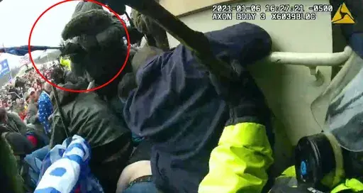 This image from police body-worn camera video, contained and annotated in the Justice Department's sentencing memorandum against Michael Joseph Foy, shows Foy swinging his hockey stick as he lunges at the police line, at the U.S. Capitol on Jan. 6, 2021, in Washington. (Department of Justice via AP, File)