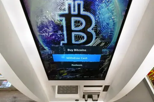 In this Feb. 9, 2021, file photo, the Bitcoin logo appears on the display screen of a cryptocurrency ATM in Salem, N.H.  Alternative finance has captured the attention of investors across the U.S. As the 2022 tax season approaches, traders who are new to cryptocurrency taxation will have to contend with the IRS’ rules for reporting on taxable events.   (AP Photo/Charles Krupa, File)