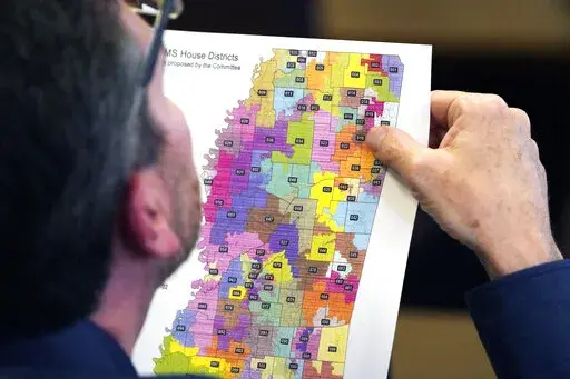 Rep. Dan Eubanks, R-Walls, examines a copy of the House redistricting map during a meeting of the House Legislative Reapportionment Committee, Sunday, March 27, 2022, at the Mississippi Capitol in Jackson. (AP Photo/Rogelio V. Solis)