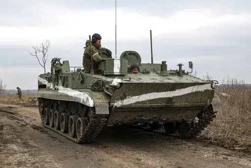 An armored vehicle rolls outside Mykolaivka, Donetsk region, the territory controlled by pro-Russian militants, in eastern Ukraine, Sunday, Feb. 27, 2022. Fighting also raged in two eastern territories controlled by pro-Russia separatists. (AP Photo)