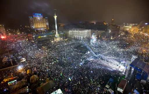 In this Jan. 1, 2014, file photo Pro-European Union activists hold lights as they sing the Ukrainian national anthem, celebrating the New Year in Kyiv's main square. At least 100,000 Ukrainians gathered in a sign of support for integration with Europe. On Nov. 21, 2023, Ukraine marks the 10th anniversary of the uprising that eventually led to the ouster of the country’s Moscow-friendly president. (AP Photo/Efrem Lukatsky, file)