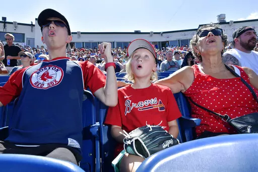 From left, Wyatt Smith, 17, of Waterville, Maine, Tessa Dutil, 9, of Sidney, Maine, and their grandmother Anne Smith, of Watervillle, Maine, react to a hit during the game between the Portland Sea Dogs and the Hartford Yard Goats, Sunday, August 28, 2022, at Hadlock Field in Portland, Maine. Across the northeastern U.S., outdoor businesses are profiting from the unusually dry weather. (AP Photo/Josh Reynolds)