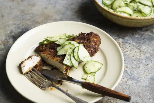 This image released by Milk Street shows a recipe for fried Dijon chicken with a cucumber dill salad. (Milk Street via AP)