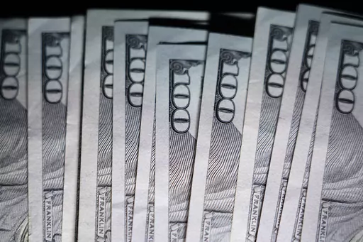 U.S. $100 bills are seen, July 14, 2022, in Marple Township, Pa. Grandparents often want to help their grandchildren financially, but they aren’t always sure where to start. The first step, financial experts recommend, is to guard against being overly generous, which can hurt grandparents’ own finances. (AP Photo/Matt Slocum, File)