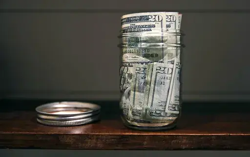 A canning jar filled with money sits on a shelf in East Derry, N.H., June 15, 2018. (AP Photo/Charles Krupa, File)