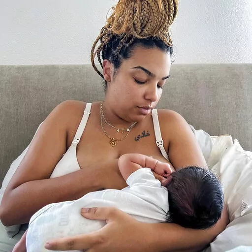 In this photo provided by Mark Godbolt Jr., his wife, Jade Godbolt, nurses her newborn child at their Dallas-area home in October 2022. She and her husband chose a home birth for their third child. Godbolt, 31, says there were no complications and she and her son are doing well. "I believed that my body could do what it was made to do and I wanted to be in the comfort of my home to do that,'' she said. (Mark Godbolt Jr. via AP)