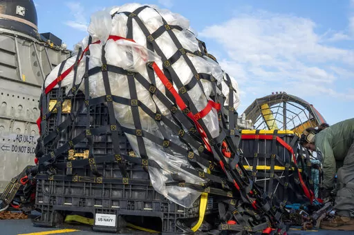In this image released by the U.S. Navy, sailors assigned to Assault Craft Unit 4 prepare material recovered off the coast of Myrtle Beach, S.C., in the Atlantic Ocean from the shooting down of a Chinese high-altitude balloon, for transport to the FBI, at Joint Expeditionary Base Little Creek in Virginia Beach, Va., on Feb. 10, 2023. U.S. officials say the military has finished efforts to recover the remnants of the large balloon and analysis of the debris so far reinforces conclusions that it w
