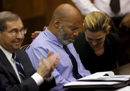 Lamar Johnson, center and his attorneys react on Tuesday, Feb. 14, 2023, after St. Louis Circuit Judge David Mason vacated his murder conviction during a hearing in St. Louis, Mo. Johnson served nearly 28 years of a life sentence for a killing that he has always said he didn't commit. (Christian Gooden/St. Louis Post-Dispatch via AP, Pool)