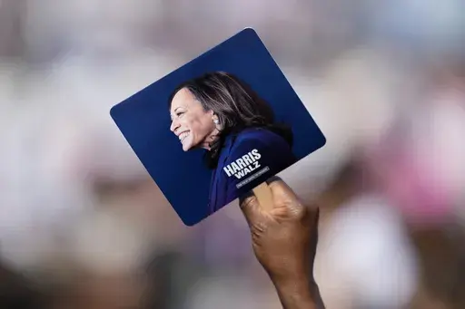 A supporter holds a sign at a campaign rally for Democratic presidential nominee Vice President Kamala Harris outside the Atlanta Civic Center, Saturday, Nov. 2, 2024. (AP Photo/Brynn Anderson)