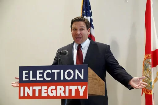 Florida Gov. Ron DeSantis asks the crowd "How about Virginia," as he arrives at an event in West Palm Beach, Fla., to announce proposed election reform laws, Wednesday, Nov. 3, 2021.  Republicans promoting claims of widespread voter fraud in at least two politically important states are turning to a new tactic to appease voters who falsely believe the 2020 presidential election was stolen: election police. The efforts in Florida and Georgia to establish law enforcement units dedicated to investi