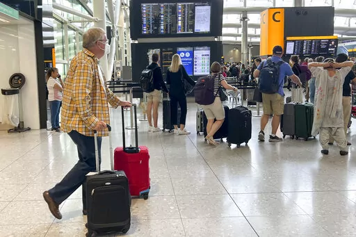Travellers at Heathrow airport, in London, Wednesday, July 13, 2022. Heathrow Airport has introduced a cap on passenger numbers this summer as the aviation sector struggles to cope with demand for travel. No more than 100,000 daily passengers will be able to depart from July 12 until Sept. 11, the west London airport announced. (AP Photo/Alberto Pezzali)