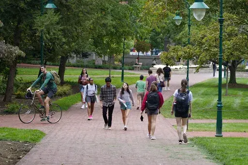 Students walk to and from classes on the Indiana University campus, Thursday, Oct. 14, 2021, in Bloomington, Ind. Between fall 2019 and 2021, college enrollment nationwide fell by nearly a million students — and for a number of financial reasons, this fall is an ideal time for students to resume their education to attain a degree or credential. The advantage of earning a degree is still evident since higher education typically results in bigger lifetime earnings and postponing your education m