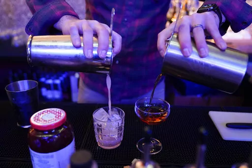 Gregory Megner, general manager and mixologist at Baltimore Spirits Company, pours two mixed drinks _ a "Peanut Butter Jelly Thyme" on the left, and a "Best Cup of Coffee in a Manhattan" _ containing whiskey distilled on premises, Wednesday, Feb. 8, 2023, in Baltimore. Spirits have surpassed beer for U.S. market share supremacy, led by a resurgent cocktail culture — including the popularity of ready-to-drink concoctions, according to a spirits industry group. In 2022, spirits gained market sha