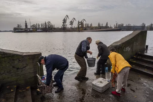 Residents of the recently liberated city of Kherson collect water from the Dnipro river bank, near the frontline, southern Ukraine, Monday, Nov. 21, 2022. (AP Photo/Bernat Armangue)