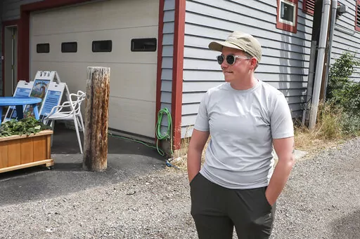 Ash Hermanowski, the food access and operations manager of the Jackson Cupboard, poses for a portrait on Wednesday, Aug. 24, 2022,  in Jackson Hole, Wyo. Hermanowksi hands out meals from a commercial garage downtown after the nonprofit was forced out of a previous location by a malfunctioning sprinkler. As the Federal Reserve's annual Jackson Hole economic symposium gets under way Thursday, some of the very problem federal officials are grappling with – high inflation, soaring home prices, and